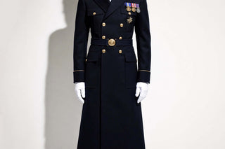 A perfectly tailored navy dress uniform coat with polished brass buttons and white gloves — the embodiment of dignified dressing