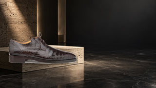 Mezlan Dandy alligator derby in a modern stone editorial setting