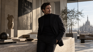 Creative director in dark tailoring in a contemporary Milan atelier.