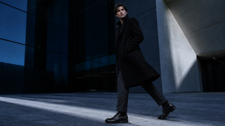 Model wearing Mezlan Riccardo black crocodile boots in contemporary Milan architecture