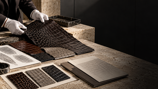 Leather artisan comparing crocodilian scale samples in a modern Milan materials studio