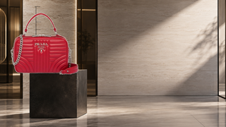Prada Diagramme red quilted leather shoulder bag displayed in a contemporary Milan fitting studio.