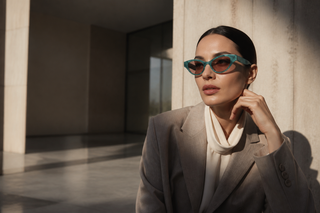 Woman wearing the exact green Gucci GG1298S sunglasses in modern Italian architecture