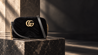 Gucci GG Marmont black velvet shoulder bag in a modern stone interior