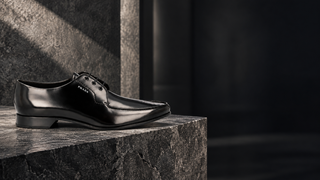 Prada black leather Oxford dress shoe in a modern architectural setting