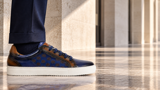 Mezlan blue leather low-top sneaker with a tailored navy suit