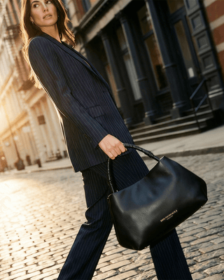 Fashionable woman holding a Bruno Magli handbag, epitomizing luxury Italian handbags with elegance and style.