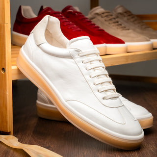 Zelli Italia Gotti white Italian soft-suede minimalist sneaker with a gum rubber outsole on a wooden shelf.