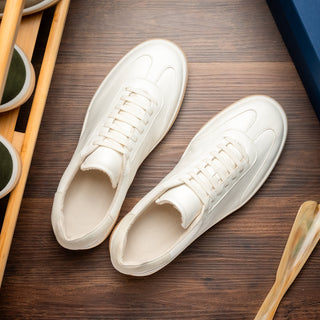Zelli Italia Gotti white Italian soft-suede minimalist sneakers with a round toe and rubber sole on a wooden surface.