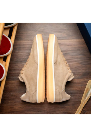 Zelli Italia Gotti taupe suede and leather sneakers with a rubber sole, viewed from above on a wooden surface.