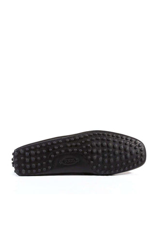 Black leather Tods Gommini driving loafer showing the signature rubber pebble sole and square toe design.